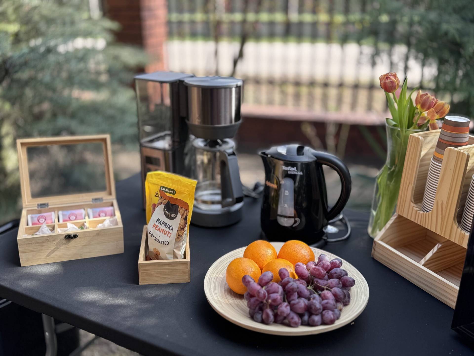 Strefa klienta na planie filmowym z kanapą, stolikiem kawowym i ekspressem do kawy